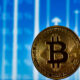 An image of a Bitcoin in front a background with arrows pointing up